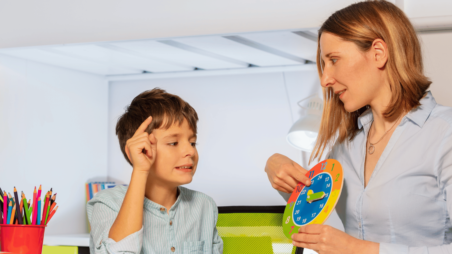 A woman assisting a boy with a clock, emphasizing social communications.