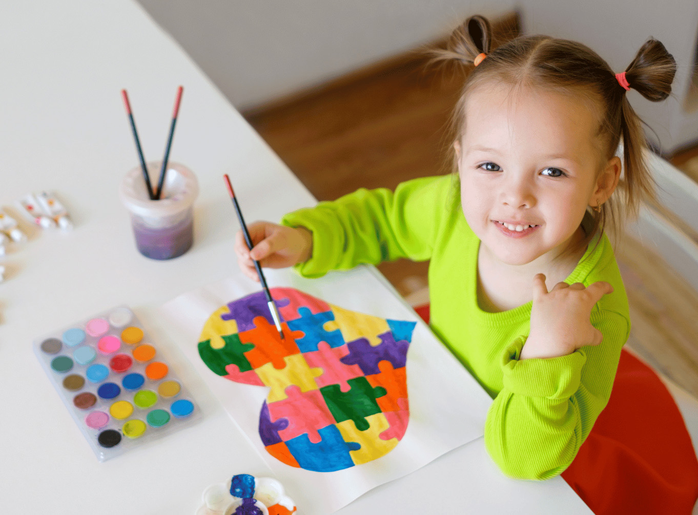 Little girl painting with a brush.