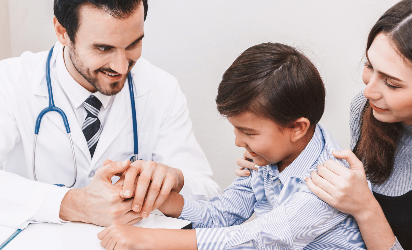 A doctor carefully examines the hand of a child, possibly assessing for signs of autism.